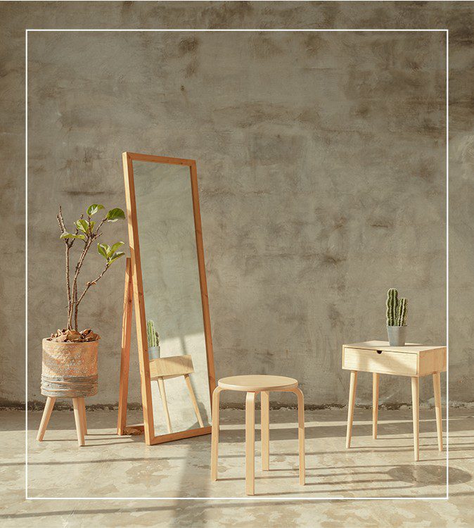 A mirror and stool in front of a wall.